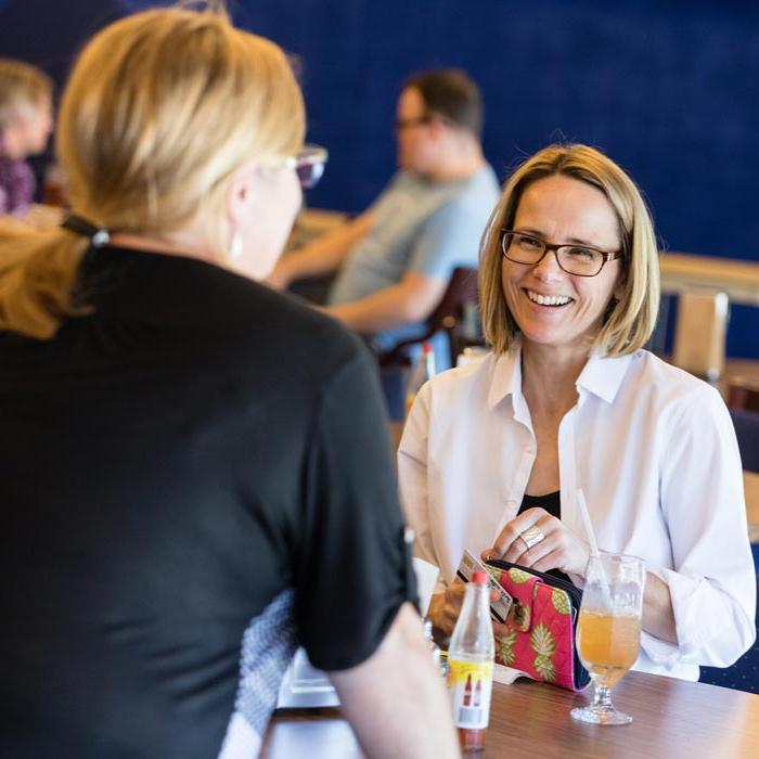 Two LTSS students talking at a table during class break